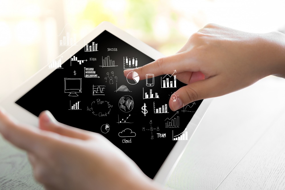 Una persona utilizando una tablet con gráficos e indicadores digitales, representando la transformación digital de una PyME.